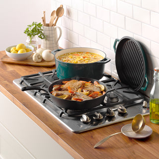 taste of home enameled cast iron dutch oven and preseasoned skillet on gas stove with food