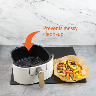 air fryer basket with parchment liner with air fried vegetables beside it and call out "prevents messy clean-up" on gray table
