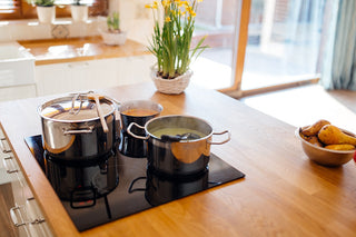smooth top range with pots and pans cooking on kitchen island