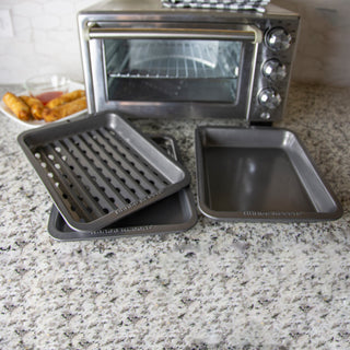 3 pieces of nonstick bakeware for a toaster oven with food in background