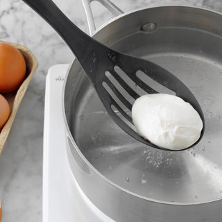 taste of home nylon slotted spoon lifting egg out of water in sauce pan