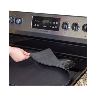 Pulling back the corner of the stove protector mat to demonstrate the messy burner that the cover will hide from view when the stove is not in use.