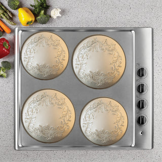 4 pieces ivy embossed decorative burner covers in copper colored metal shown in use on a stove top
