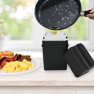 Black Fat Trapper System with a frying pan over it, on a kitchen counter with food in the background.