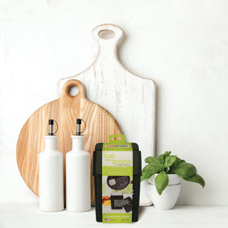 Fat Trapper System sitting in front of wooden cutting boards