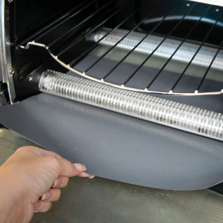 inserting the toaster oven liner into a toaster oven crumb tray