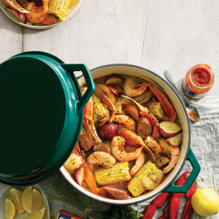 taste of home sea green enameled cast iron dutch oven with seafood boil on table with hot sauce and lemons