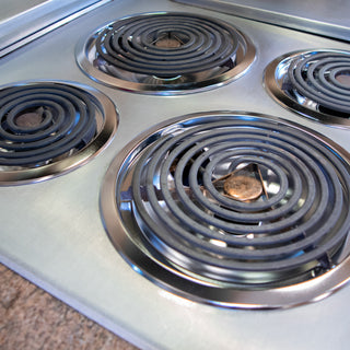 photo of dirty drip bowls on stove