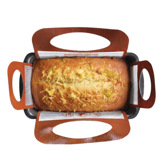 baked quick loaf in a terracotta silicone baking sling inside a 9 x 5 inch loaf pan on white background