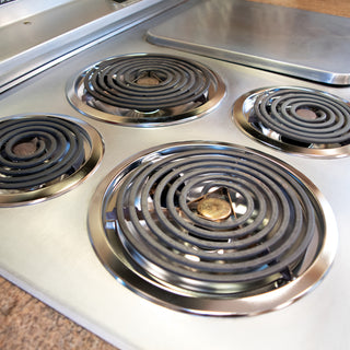 Stainless steel electric stove top with four coil burners.