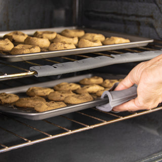 Removing cookies from oven demonstrating how the oven rack edge guard would protect your hands.