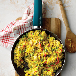 Taste of Home Skillet on counter with saffron rice on cutting board with towel