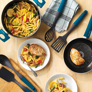 Cooking scene with pasta, chicken, and Taste of Home Nylon tools and cookware on a wooden surface