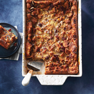 Baked bread pudding in a white stoneware dish on a blue background