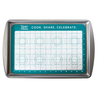 Baking tray with grid and measurement lines on a teal background, featuring the 'Taste of Home' brand.