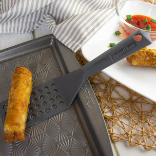 Baking sheet demonstrating the use of the taste of home vented turn with egg rolls and sauce.