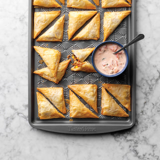 Southwest appetizers and creamy salsa on a taste of home nonstick metal baking sheet on a counter